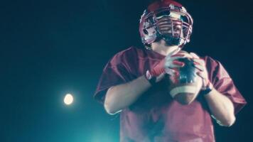 An American football player practicing throwing and catching the ball on a field video