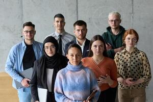 A diverse and determined team of business professionals stands confidently in an office, ready to tackle new business plans and challenges with a focus on success and growth photo
