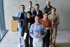 A diverse and determined team of business professionals stands confidently in an office, ready to tackle new business plans and challenges with a focus on success and growth photo