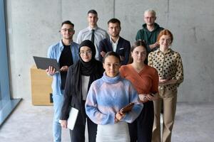 A diverse and determined team of business professionals stands confidently in an office, ready to tackle new business plans and challenges with a focus on success and growth photo