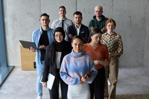 A diverse and determined team of business professionals stands confidently in an office, ready to tackle new business plans and challenges with a focus on success and growth photo