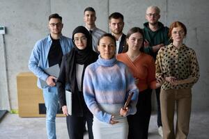 A diverse and determined team of business professionals stands confidently in an office, ready to tackle new business plans and challenges with a focus on success and growth photo