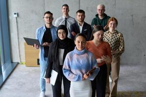 A diverse and determined team of business professionals stands confidently in an office, ready to tackle new business plans and challenges with a focus on success and growth photo