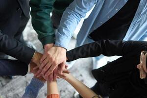 A top view of business people joining hands in a circle, symbolizing unity, collaboration, and shared success in the workplace photo