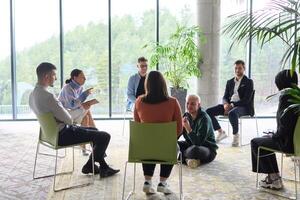 Corporate business team meeting with a manager or coach. Group of happy diverse, multiracial people sitting in a circle photo