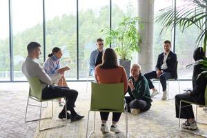 Corporate business team meeting with a manager or coach. Group of happy diverse, multiracial people sitting in a circle photo