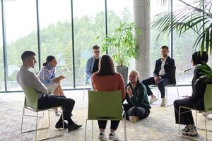 Corporate business team meeting with a manager or coach. Group of happy diverse, multiracial people sitting in a circle photo