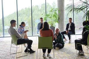 Corporate business team meeting with a manager or coach. Group of happy diverse, multiracial people sitting in a circle photo