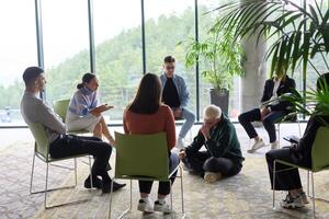 Corporate business team meeting with a manager or coach. Group of happy diverse, multiracial people sitting in a circle photo
