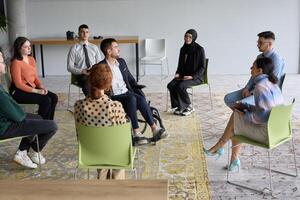 Corporate business team meeting with a manager or coach. Group of happy diverse, multiracial people sitting in a circle photo