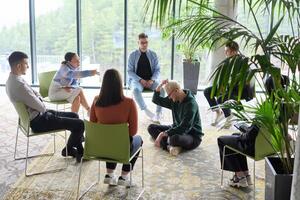 Corporate business team meeting with a manager or coach. Group of happy diverse, multiracial people sitting in a circle photo