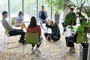 Corporate business team meeting with a manager or coach. Group of happy diverse, multiracial people sitting in a circle photo
