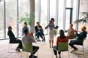 Corporate business team meeting with a manager or coach. Group of happy diverse, multiracial people sitting in a circle photo