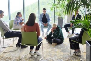 Corporate business team meeting with a manager or coach. Group of happy diverse, multiracial people sitting in a circle photo