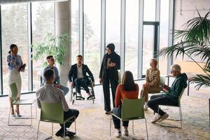 Corporate business team meeting with a manager or coach. Group of happy diverse, multiracial people sitting in a circle photo