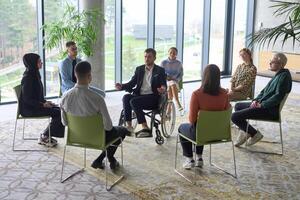 Corporate business team meeting with a manager or coach. Group of happy diverse, multiracial people sitting in a circle photo