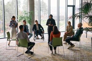 Corporate business team meeting with a manager or coach. Group of happy diverse, multiracial people sitting in a circle photo