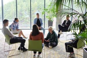 Corporate business team meeting with a manager or coach. Group of happy diverse, multiracial people sitting in a circle photo