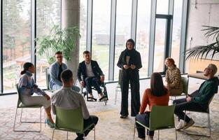 Corporate business team meeting with a manager or coach. Group of happy diverse, multiracial people sitting in a circle photo