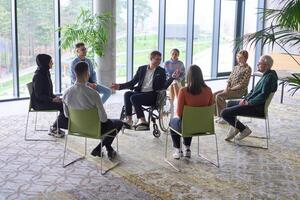 Corporate business team meeting with a manager or coach. Group of happy diverse, multiracial people sitting in a circle photo