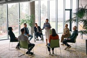 Corporate business team meeting with a manager or coach. Group of happy diverse, multiracial people sitting in a circle photo