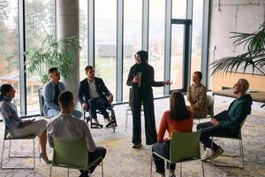 Corporate business team meeting with a manager or coach. Group of happy diverse, multiracial people sitting in a circle photo