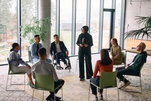 Corporate business team meeting with a manager or coach. Group of happy diverse, multiracial people sitting in a circle photo