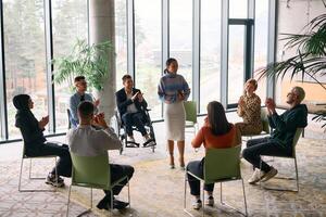 Corporate business team meeting with a manager or coach. Group of happy diverse, multiracial people sitting in a circle photo
