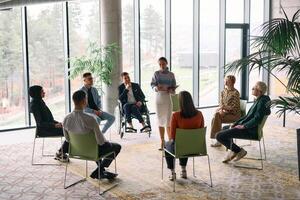 Corporate business team meeting with a manager or coach. Group of happy diverse, multiracial people sitting in a circle photo