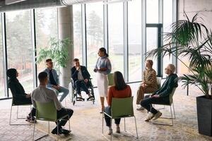 Corporate business team meeting with a manager or coach. Group of happy diverse, multiracial people sitting in a circle photo