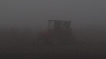 A tranquil and serene misty farm landscape featuring an isolated tractor hidden within the fog video