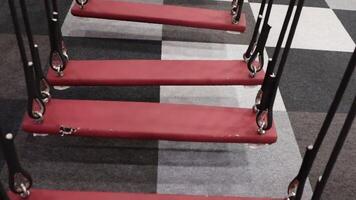 A closeup view of a red swing set situated on modern, stylish flooring surfaces video