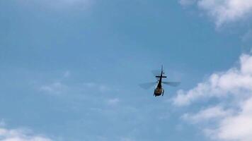 Handheld Shot Of Helicopter Flying In Blue Sky With White Clouds Away From Camera video