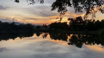 A lake with trees and a sunset in the background video