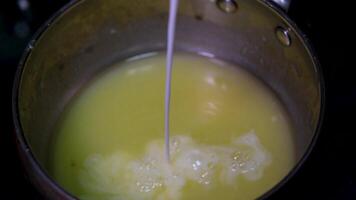 milk add butter Swirling melting butter in a metal saucepan on a flat stovetop hot yellow butterfat swirls and melts into a puddle of grease. Top down view for gif recipes and unhealthy video