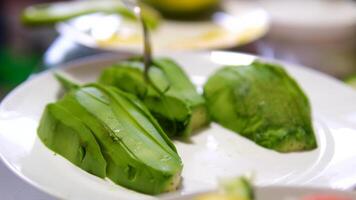 female hand stacks fresh avocado slices. Raw avocado pieces close up. Shot in slow motion with RED camera. video