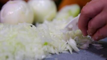 Chef chopping a red onion with a knife on the cutting board, macro close up of cutting red onion on professional kitchen. video