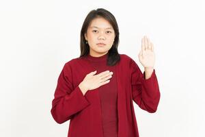 Swearing Gesture Of Beautiful Asian Woman Wearing Red Shirt Isolated On White Background photo