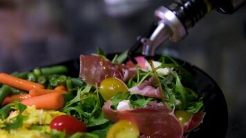 drizzle olive oil over prosciutto mozzarella salad and omelette Appetizing salad with prosciutto, baked pumpkin, cheese, lettuce, tomatoes and sesame seeds video