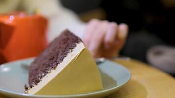 Close-Up of Chocolate Cake Slice Being Spooned on a Plate, Creamy Sauce Drizzled video