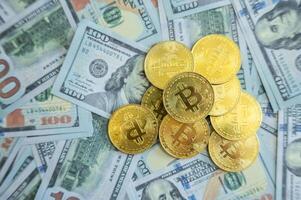 Bitcoin tokens placed on America one hundred dollars banknote. Bitcoin is a digital currency which operates free of any central control or the oversight of banks or governments. photo