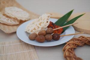 rice with skewered quail eggs and crackers on wood background. Selective focus. photo