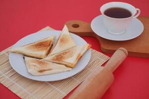 Toasted bread on a white plate isolated on a red background. photo