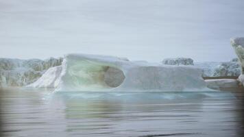 A solitary iceberg floats serenely in calm arctic waters during daylight video