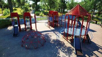 Colorful playground structures in a sunny park setting with trees video