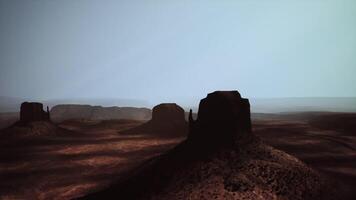 Desert landscape at dusk with silhouetted rock formations in the distance video