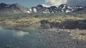 serein bord du lac vue avec montagnes et luxuriant verdure dans lumière du jour video