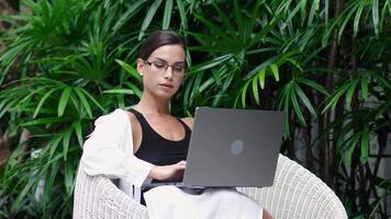 Middle-aged female trader wearing eyeglasses working looking at laptop computer screen reflecting in glasses thinking analyzing online trading market finance digital data. video