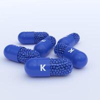 Vitamin K, Blue Capsules, Granules and Whtie Background photo