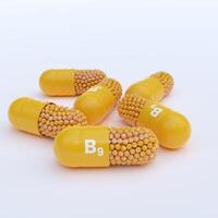 Vitamin B9 With Yellow Capsules, Granules and White Background photo
